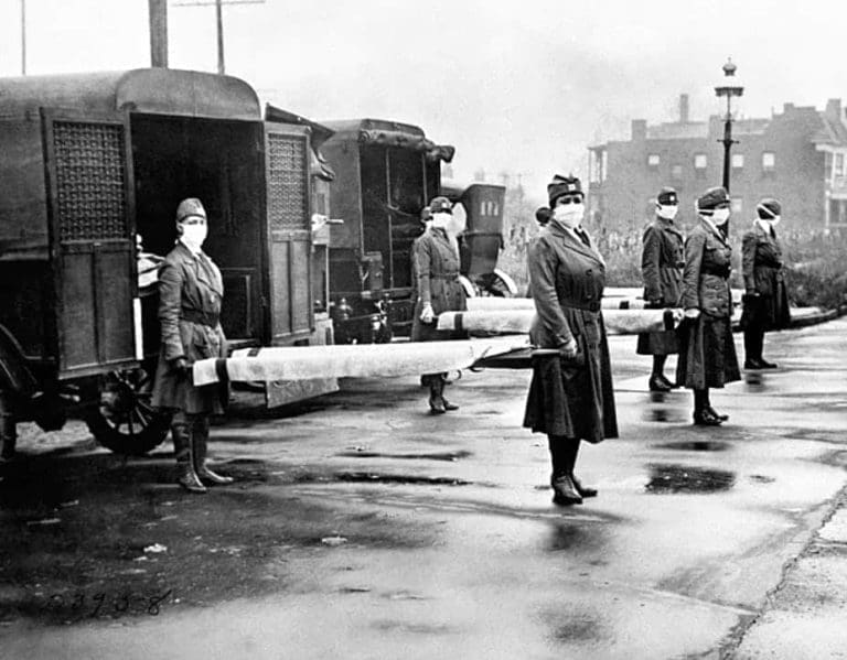 The St Louis Red Cross Motor Corps on duty with mask-wearing women holding stretchers at the backs of ambulances during the global flu epidemic, St Louis, Missouri, October 1918.