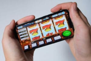 The Surprising Numbers Behind NZ Online Casino Growth A person using a phone device to play a slot machine game